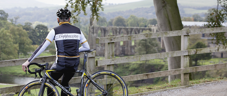 A cyclist looks over the Bolton Abbey ruins
