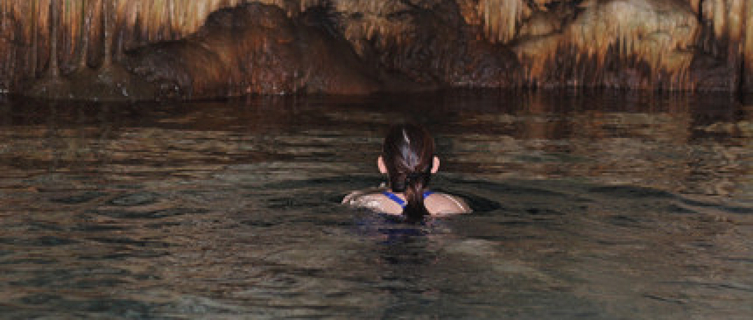 A swimmer braves the darkness of the underground caves